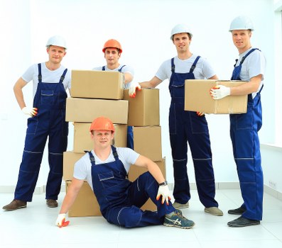 Local moving team handling packed boxes and furniture in a home