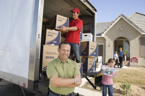 Movers carrying furniture through a narrow hallway in a house