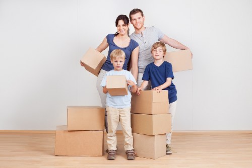 Professional mover carrying boxed household items during a house removal