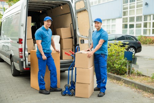 Removal workers unloading furniture carefully at a new property