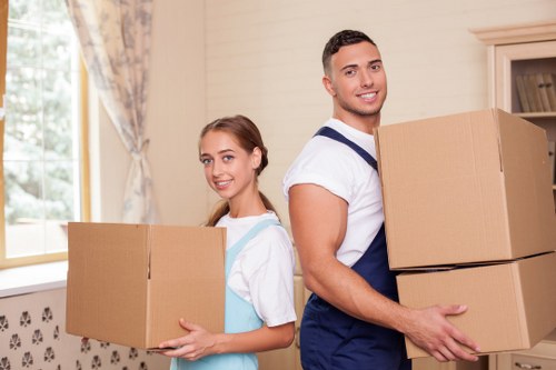Professional movers carrying furniture during a local house relocation