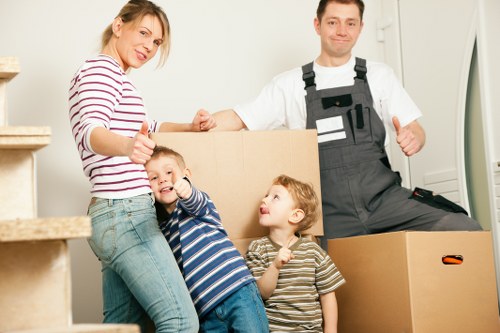 Local removal team carrying bulky furniture through a narrow hallway